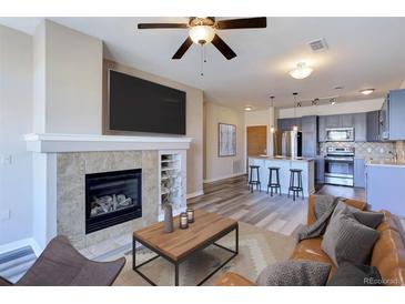 Cozy living room showcasing a fireplace and seamlessly connected modern kitchen at 13456 Via Varra # 406, Broomfield, CO 80020