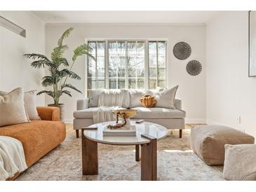 Bright living room featuring modern decor, a cozy couch, a round marble coffee table, and a large window at 1410 Vine St # 3, Denver, CO 80206