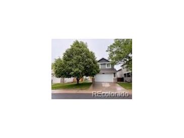 Charming two-story home with a well-manicured lawn and mature shade tree at 6973 Summerset Ave, Longmont, CO 80504