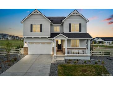 Charming two-story home featuring a spacious two-car garage, inviting front porch, and professionally landscaped front yard at 7137 S Vandriver Way, Aurora, CO 80016