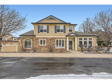 Inviting two-story home featuring a stone facade, blue shutters, and a well-maintained front yard at 4396 S Quail Way, Littleton, CO 80127