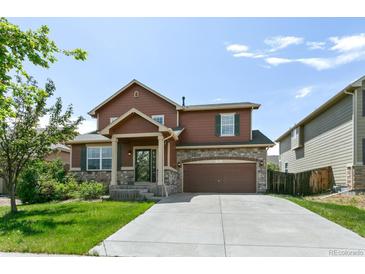 Charming two-story home with a well-manicured lawn and a welcoming front porch at 9919 Memphis St, Commerce City, CO 80022