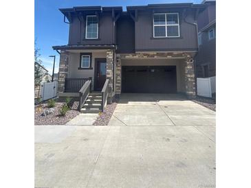 Charming two-story home with a stone facade, covered porch, and a spacious two-car garage at 2176 S Haleyville Way, Aurora, CO 80018