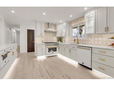 Bright kitchen featuring white cabinetry, stainless steel appliances, and stylish backsplash at 3281 Vivian Dr, Wheat Ridge, CO 80033