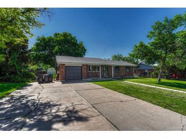 Charming brick home featuring a one-car garage and well-maintained lawn, creating appealing curb appeal at 7479 Pierce St, Arvada, CO 80003