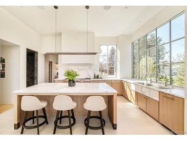 Spacious kitchen with eat-in island, stone counters and backsplash, and pendant lighting at 20 Viking Dr, Cherry Hills Village, CO 80113