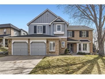 Charming two-story home with brick and siding, featuring a three-car garage and well-maintained front yard at 286 Warwick Pl, Castle Pines, CO 80108