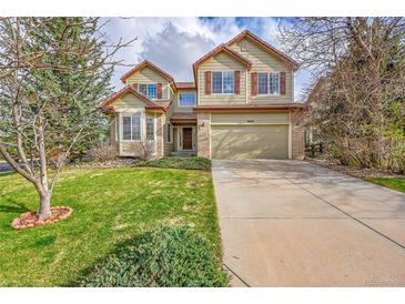Charming two-story home featuring a well-manicured lawn, mature trees, and an attached two-car garage at 18142 E Oakwood Pl, Aurora, CO 80016