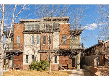 Modern townhouse featuring a brick and tan facade, balconies, and a small front yard area at 4544 Utica St, Denver, CO 80212