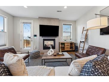 Cozy living room featuring a fireplace, TV, stylish decor, and access to outdoor area at 1259 Perry St, Denver, CO 80204