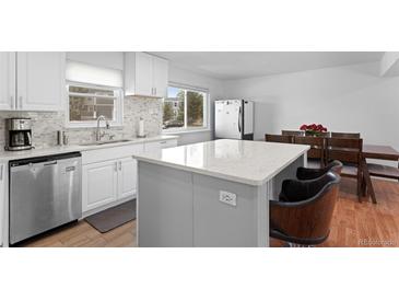 Bright kitchen featuring stainless steel appliances, a center island, and windows for natural light at 23 S Nome St # A, Aurora, CO 80012