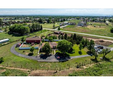 Expansive property with horse amenities, large barn, and well-maintained grounds on a sunny day at 17450 E 14Th Dr, Aurora, CO 80011