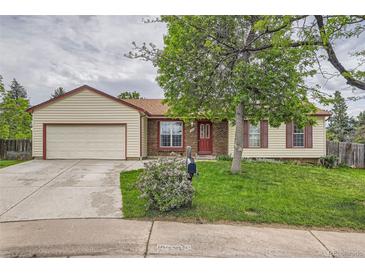 Charming single-Gathering home featuring a well-maintained lawn, mature tree, and a red brick entryway at 18240 E Mexico Pl, Aurora, CO 80017