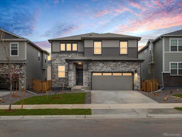Stunning two-story home with a stone facade and a spacious two-car garage, set against a colorful sky at 559 Homestead Ave, Brighton, CO 80601
