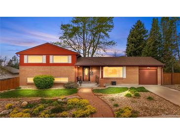 Charming brick home featuring manicured lawn and stone walkway to the front door at 6919 S Valentia St, Centennial, CO 80112