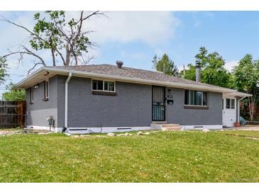 Charming single-story home with a well-maintained lawn, featuring a gray brick facade and cozy curb appeal at 2612 Meadowbrook Dr, Denver, CO 80221