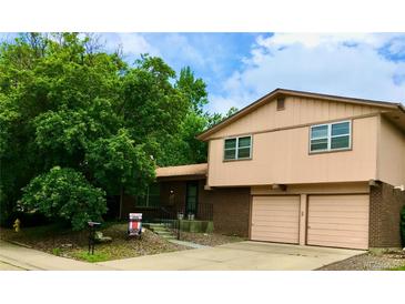 Charming two-story home with a brick facade and an attached two-car garage at 6411 W 82Nd Dr, Arvada, CO 80003