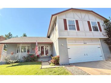 Charming two-story home featuring a well-manicured lawn, red window shutters, and a welcoming front porch with an American flag at 5255 S Waco St, Centennial, CO 80015