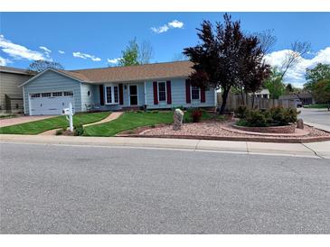 Charming single-story home with a well-manicured lawn, red accents, and mature trees creating an inviting curb appeal at 16308 E Wyoming Dr, Aurora, CO 80017