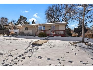 Ranch style home with snow covered yard and red deck at 5648 E Greenwood Pl, Denver, CO 80222