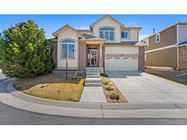 Charming two-story home with a well-maintained lawn, mature tree, attached two car garage and neutral color palette at 1208 S Valentia Ct, Denver, CO 80247
