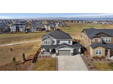 Beautiful two-story home with a three-car garage, manicured lawn, and mountain views at 806 Flora View Dr, Erie, CO 80516