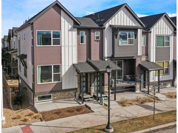 Modern townhome showing its stylish, two-story elevation with covered entryways and balconies, set against a blue sky at 5188 Ward Rd, Wheat Ridge, CO 80033