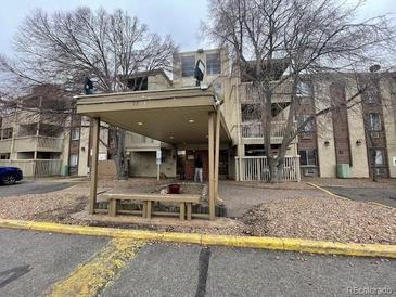 Comfortable apartment building featuring covered entry, well-maintained landscaping, and exterior benches at 1304 S Parker Rd # 346, Denver, CO 80231