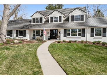Charming two-story home with a manicured lawn, rock landscaping, and a winding walkway to the front door at 7152 E Hinsdale Pl, Centennial, CO 80112