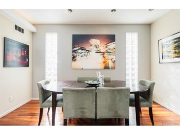 An elegant dining room with rich wood floors, modern decor, and recessed lighting features at 907 E 22Nd Ave, Denver, CO 80205