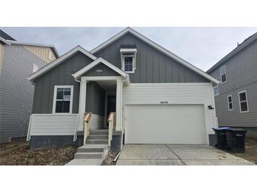 Charming two-story home featuring a two-car garage, landscaped yard, and inviting front entrance at 16478 W 92Nd Pl, Arvada, CO 80007
