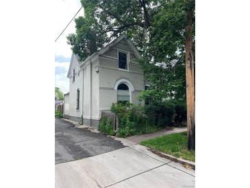 Charming two-story home with lush landscaping and architectural details, near a sidewalk and alleyway at 819 27Th St, Denver, CO 80205
