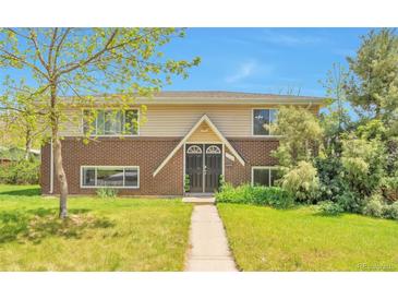 Charming brick and siding home with a well-manicured lawn and inviting entryway at 6484 Kendall St, Arvada, CO 80003