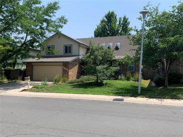 Charming two-story home with manicured lawn and mature trees providing ample shade and curb appeal at 11600 E Adriatic Pl, Aurora, CO 80014