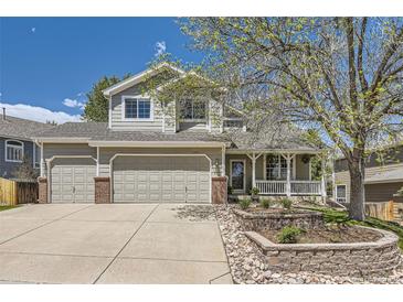 Charming two-story home featuring a large front yard, attached two-car garage, and welcoming front porch at 1153 Berganot Trl, Castle Pines, CO 80108