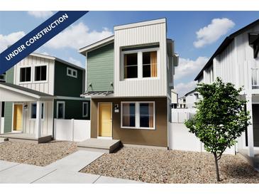 Contemporary two-story home with a yellow front door, gravel landscaping, and neutral exterior color scheme at 13059 E 103Rd Pl, Commerce City, CO 80022