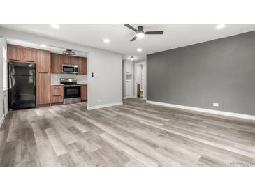 Open-concept living room featuring updated flooring and a ceiling fan at 1182 Clermont St # 201, Denver, CO 80220
