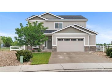 Charming two-story home with neutral siding, stone accents, an attached two car garage, and well manicured yard at 601 Morrison Dr, Frederick, CO 80530