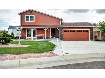 Inviting two-story home features a landscaped front yard, a ramp, and a two-car attached garage at 7300 Beech St, Arvada, CO 80005