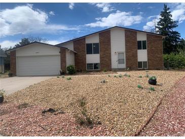 Charming two-story home features brick and siding exterior with a two-car garage and low maintenance front yard at 15873 E Hamilton Pl, Aurora, CO 80013