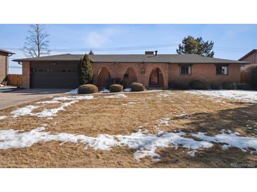 Charming brick home with arched entryway and a well-maintained front lawn in a desirable neighborhood at 4192 S Vrain St, Denver, CO 80236