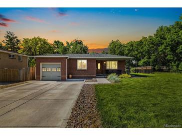 Charming brick home with a well-manicured lawn and an attached one-car garage and beautiful sunset at 7350 W 21St Ave, Lakewood, CO 80214