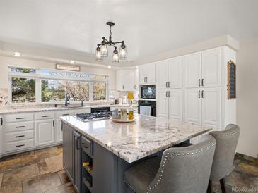 Bright, updated kitchen with granite countertops, a center island, and modern white cabinetry at 12160 Spring Creek Rd, Parker, CO 80138