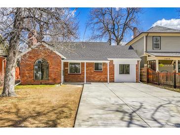 Charming brick home with a concrete driveway and manicured lawn, perfect for suburban living at 1448 Newport St, Denver, CO 80220