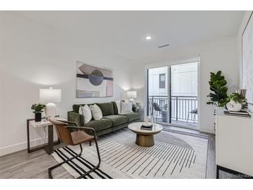 Bright living room featuring modern furnishings, stylish rug, and access to private balcony at 3500 S Corona St # 407, Englewood, CO 80113