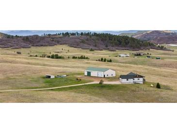 Expansive view of property featuring a house and barn with picturesque landscape and mountain views at 12747 Bestview Dr, Larkspur, CO 80118