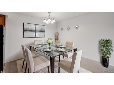 Bright dining room featuring a glass-top table with seating for six, modern lighting, and neutral decor at 7395 E Quincy Ave # 206, Denver, CO 80237
