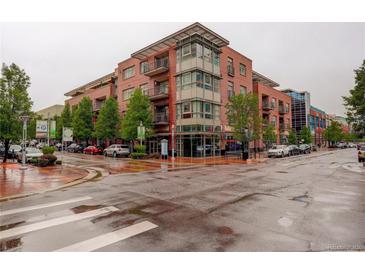 Upscale brick condominium building with modern architectural details on a wet city street at 191 Clayton Ln # 402, Denver, CO 80206