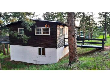 Exterior of the home with a dark siding, featuring a ramp leading to the front door, with trees surrounding at 7105 Flagstaff Rd, Boulder, CO 80302