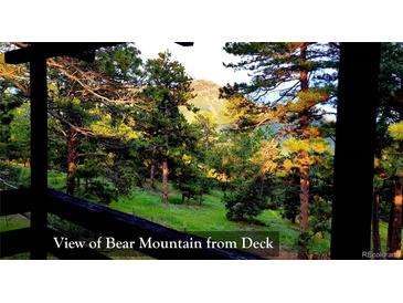 Beautiful view of Bear Mountain from the deck, surrounded by lush greenery and tall trees at 7105 Flagstaff Rd, Boulder, CO 80302